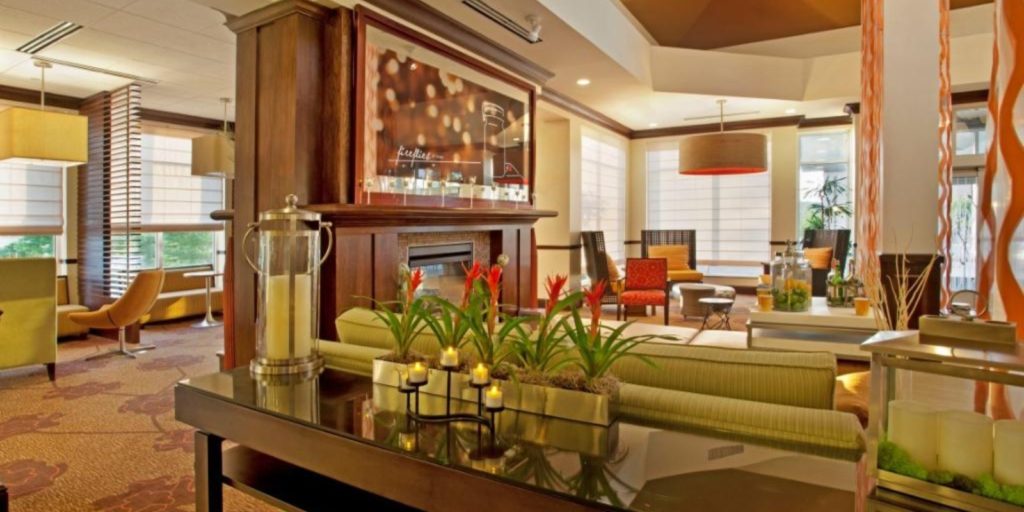bright hotel lobby with light green and yellow accents, sofas, lounge chairs and booth seating