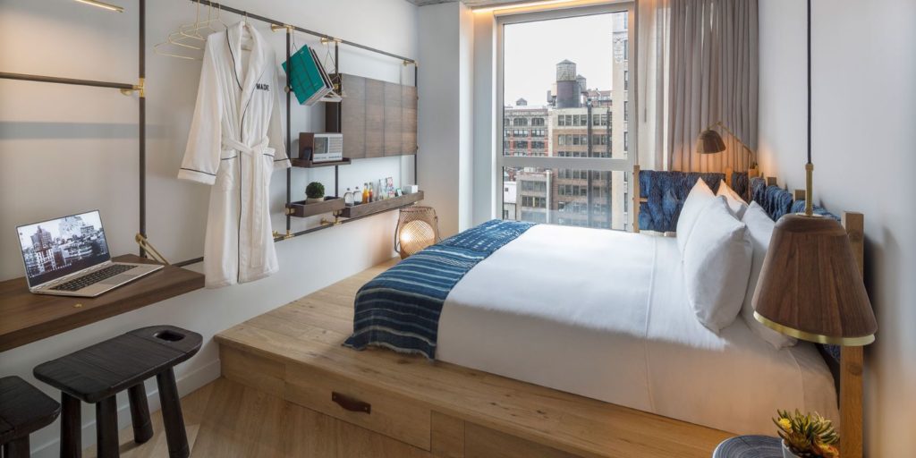 cozy hotel room overlooking a downtown industrial city scene with eclectic wooden furniture and accents